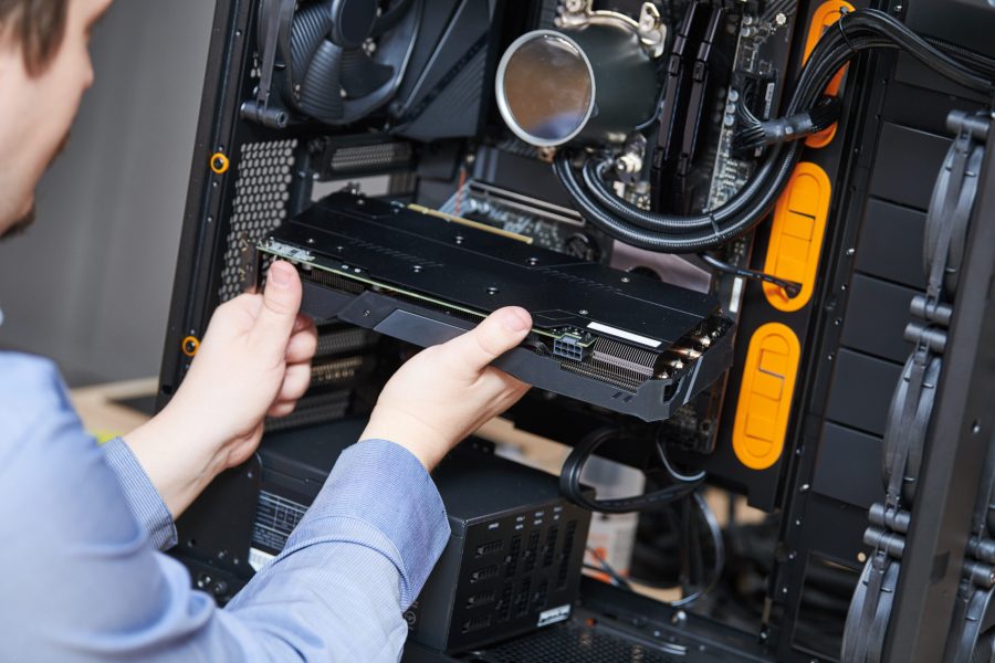 Computer maintenance upgrade and warranty repair service Computer assembling or repair service. repairman installing graphic card during maintenance or upgrade