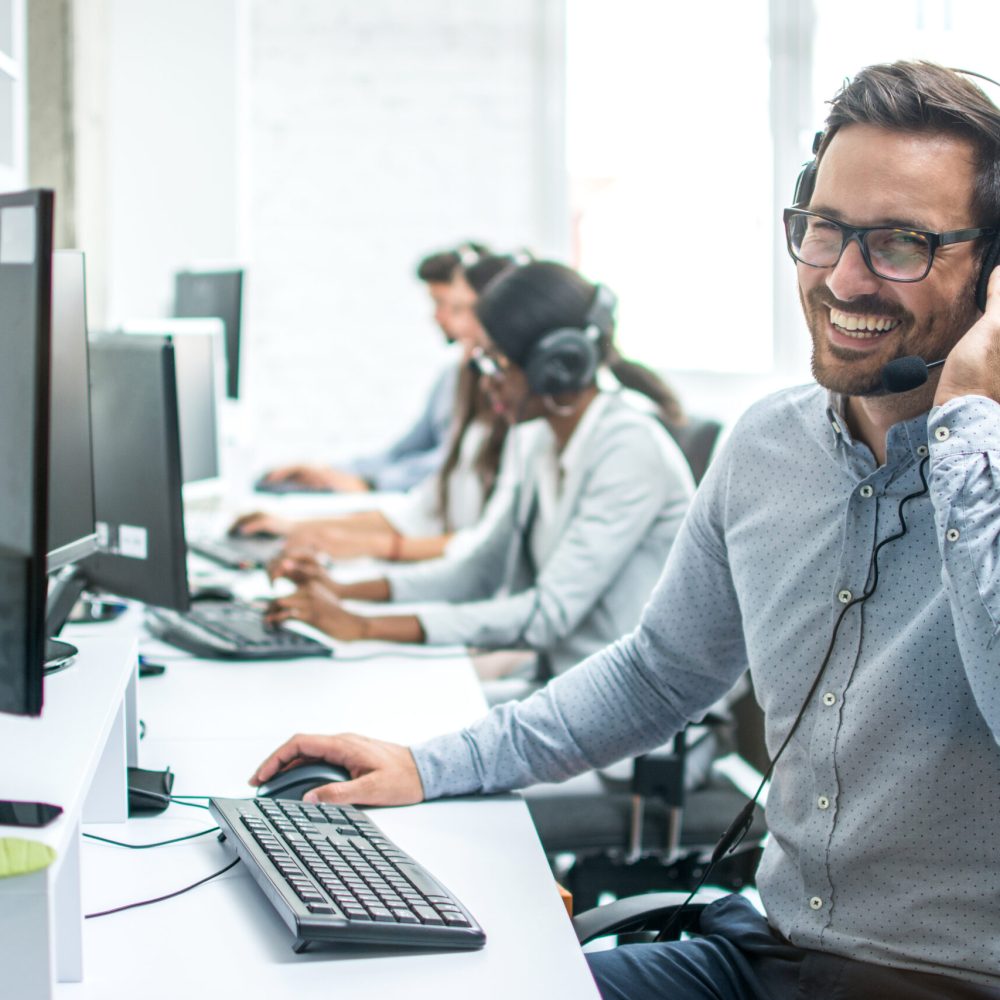 Smiling handsome customer support operator with headset working